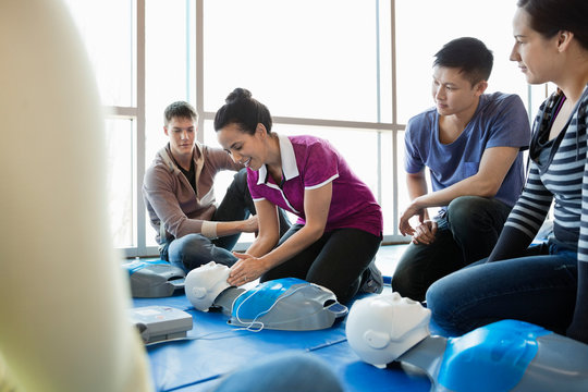 Instructor teaching CPR to class in fitness center