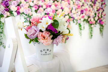 Interior in the style of French Provence. White bucket with colorful flowers ev a white whatnot. Close-up. Selective focus