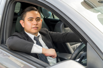 Young asian man wearing suit driving car