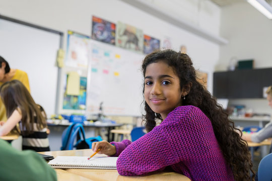 Portrait Of Confident Elementary Student In Classroom