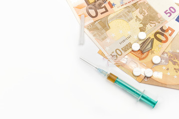 Money and pills with drugs and a syringe on isolated on white