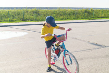 Girl learning to ride a bike. Park for families.