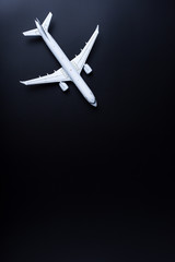 Obraz premium Airplane on black background with empty space for text. Fly travelling concept. Summer travel