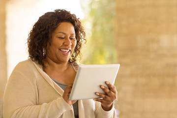 Fototapeta premium Smiling African American woman working on a tablet.