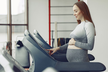 Pregnant girl in a gym. Sports girl in a sportswear.