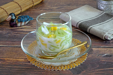 Cendol : Cendol is an iced sweet dessert, contains droplets of green pandan rice flour jelly, mixed with sliced jackfruit, young coconut meat in coconut milk and palm sugar syrup. Selective focus.