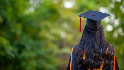 Female graduates wear black gowns and yellow tassels waiting to attend the commencement ceremony at...