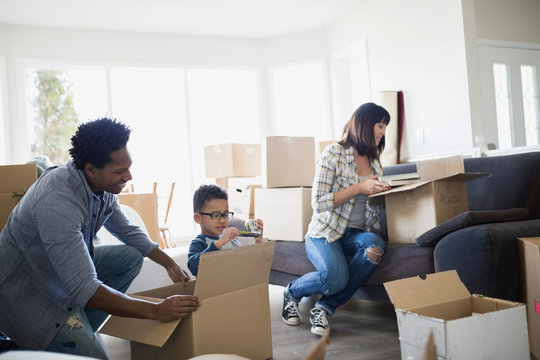 Family Unpacking Moving Boxes In Living Room