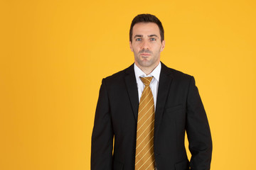 Portrait of confident businessman on yellow  background.
