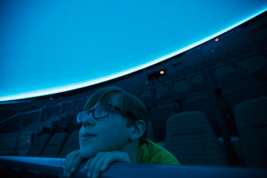 Curious boy enjoying planetarium show