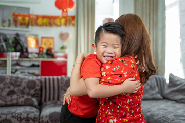 Fototapeta premium Having fun asian little boy embracing with mother.Celebration of Lunar New Year with family