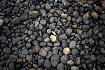 a collection of black round stones forming a pattern for background, wallpaper and web design
