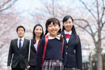 桜並木の下に立つ家族