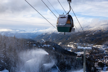 Whistler, British Columbia, Canada. Gondola going up the mountain during a vibrant and sunny winter day.