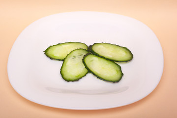 sliced fresh cucumbers on a white plate.chopped 
gherkins 
