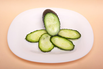 sliced fresh cucumbers on a white plate. chopped green
gherkins closeup
