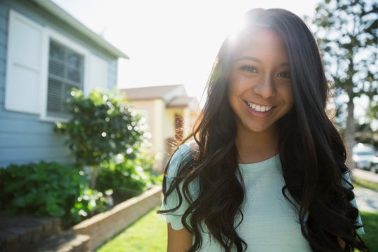 Portrait smiling brunette teenage girl sunny front yard
