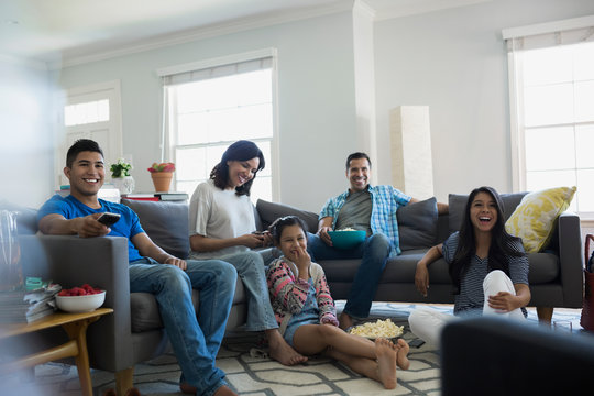 Family Watching TV With Popcorn In Living Room