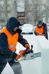 Fototapeta premium Worker cuts ice panel with gasoline saw
