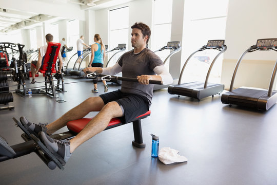 Man doing seated cable row at gym