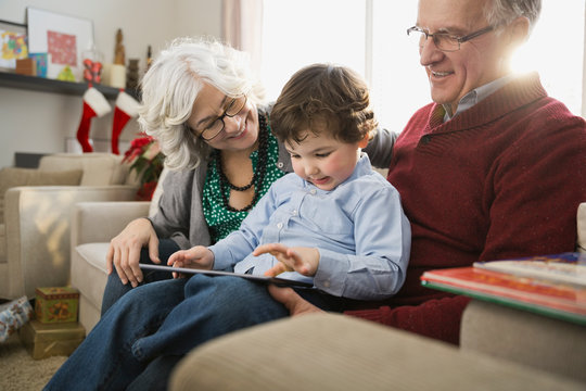 Grandparents and grandson using digital tablet together