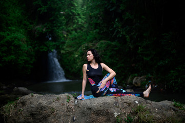 Yoga practice and meditation in nature. Woman practicing near river