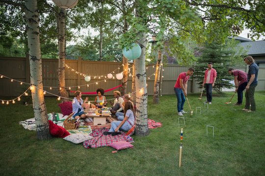 Friends Playing Croquet And Eating At Backyard Party