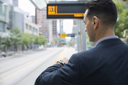 Businessman Checking The Time On Wristwatch Train Station