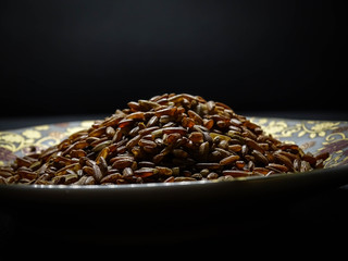 Red/brown rice isolated on black background