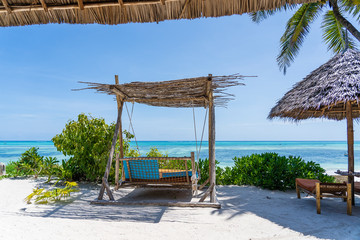 Wooden swing under a canopy on the tropical beach near sea, island Zanzibar, Tanzania, East Africa