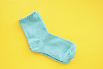A pair of mint blue cotton socks on a bright yellow background. Space for copying..