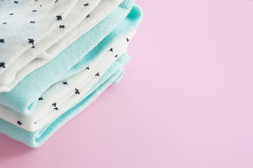 Two pairs of mint blue and two pairs of white in black speckled cotton socks on a pink background. Space for copying...