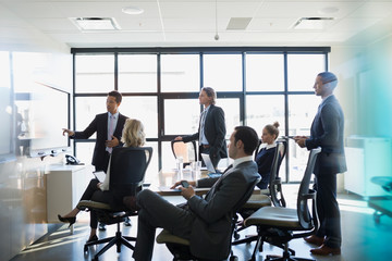 Businessman leading meeting at screen in conference room