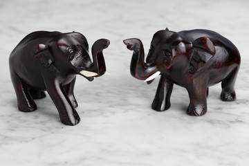 Two wood carved elephants with trunks raised signifying good luck