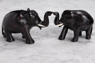 Two wood carved elephants with trunks touching and raised signifying good fortune