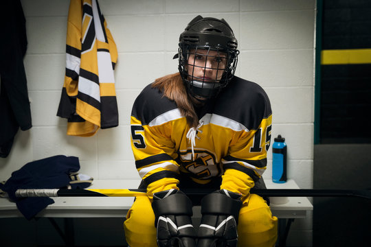 Portrait serious female ice hockey player locker room