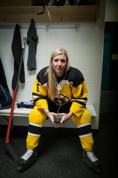 Portrait confident female ice hockey player locker room