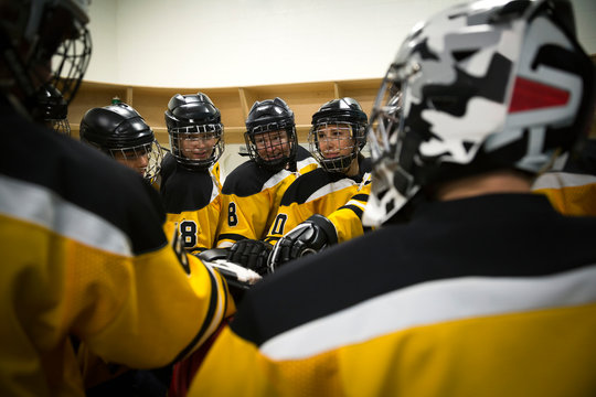 Womens ice hockey team huddling in locker room