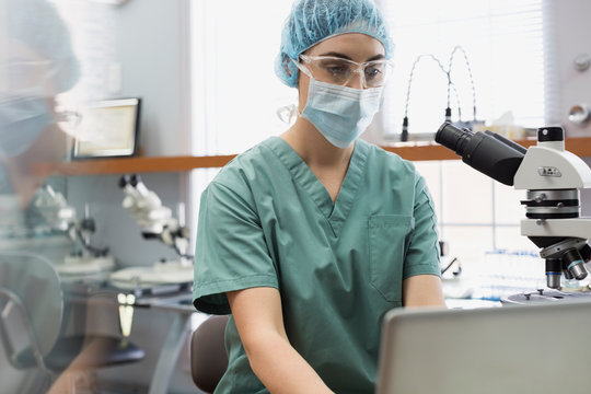 Female medical technician working at laptop in laboratory
