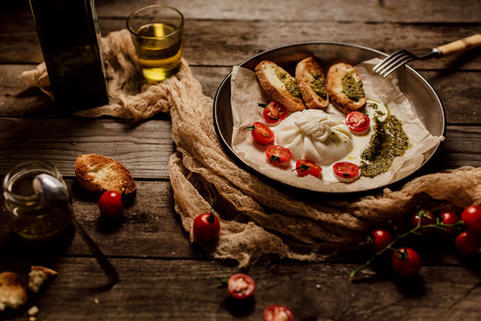 Italian Buratto cheese, delicious cheese, appetizer of cheese, cherry and arugula, cheese dish