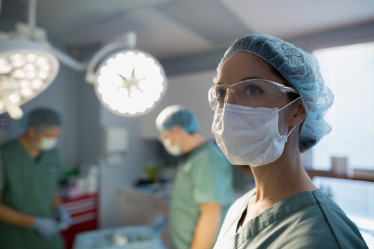 Pensive surgeon looking away in operating room