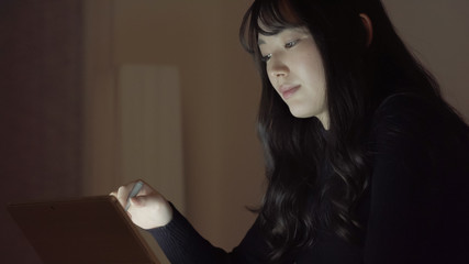 若い女性　ビジネス　残業　タブレット