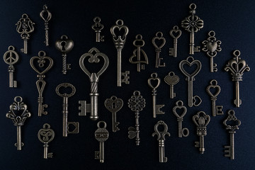 Fototapeta na wymiar Bronze keys on black background antique key still life