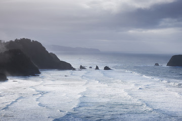 Sunlight illuminates the sea on a stormy morning on the Oregon coast
