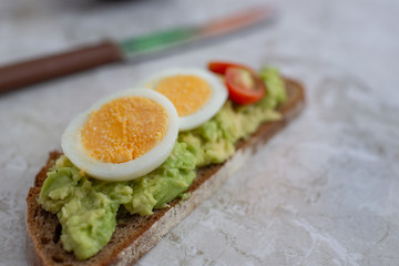 sliced avocado and egg on toasted bread for healthy breakfast or snack