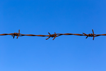 Barbed wire against blue sky