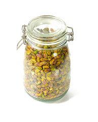 raw pistachio in a glass jar isolated on white