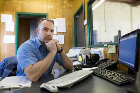 Portrait Confident Mechanic At Computer Auto Shop Office