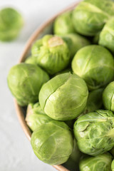 Organic raw and fresh brussel sprouts on a plate on light background