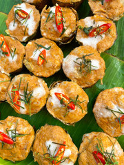 Thai steamed fish with curry paste and coconut milk wrapped in banana leaves , street food concept